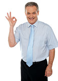 Cheerful male executive showing okay sign