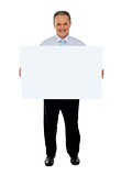Confident businessman holding blank billboard