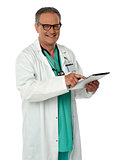 Cheerful doctor using wireless tablet device
