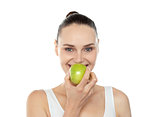 Attractive girl eating fresh juicy green apple