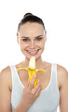 Cheerful fit woman eating banana