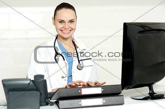 Cheerful female doctor tying on keyboard