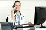 Young smiling physician sitting in clinic