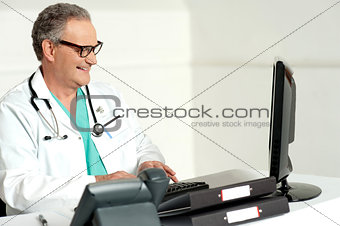 Experienced doctor working on computer