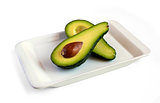 fresh avocado cut in half on square plate