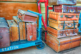 Old suitcases on trolleys in a station