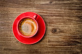View of coffee in red cup on wooden vintage table