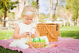 Cute Baby Girl Enjoying Her Easter Eggs on Picnic Blanket