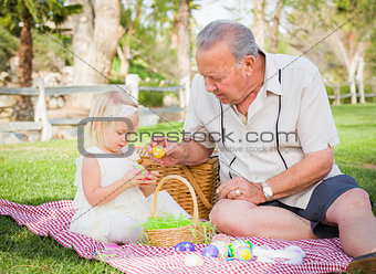 Grandfather and Granddaughter Enjoying Easter Eggs on Blanket At