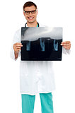 Happy young surgeon showing x-ray of a patient