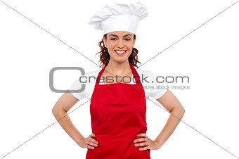 Cute female chef posing with hands on her waist