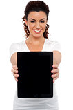 Woman holding tablet device, showing it to camera