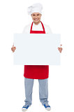 Chef holding blank white billboard. Full length shot