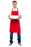Full length portrait of male chef holding pie box