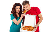 Pretty woman making her boyfriend end pizza piece