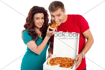 Pretty woman making her boyfriend end pizza piece