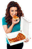 Young cheerful girl enjoying pizza alone