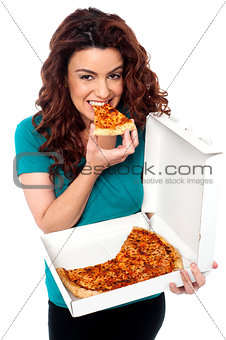 Young cheerful girl enjoying pizza alone