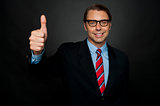 Businessman showing thumbs up sign to his team