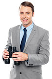 Smiling male consultant holding binoculars