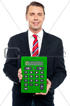 Young businessman showing big green calculator