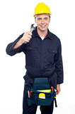Smiling repairman holding out screwdriver
