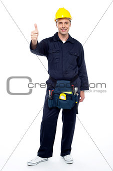 Young smiling industrial engineer showing thumbs up