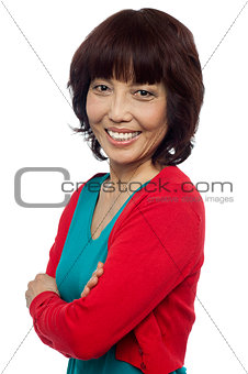 Side pose of smiling asian woman, arms crossed