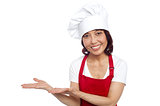 Smiling asian chef gesturing guests to take their seats
