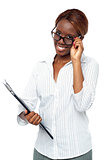 Businesswoman holding file and adjusting her spectacles