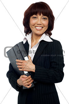 Smiling female executive holding binder