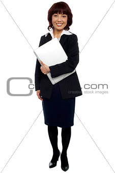 Female executive posing with laptop, full length shot