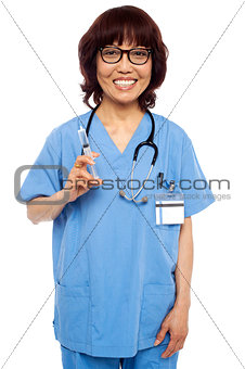 Experienced female pediatrician ready with a syringe