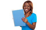 Smiling college student holding notebook