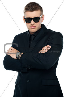 Young stylish bouncer in a black suit, arms folded