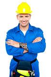 Young repairman in uniform posing with crossed arms
