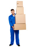 Delivery guy holding pile of cardboard boxes
