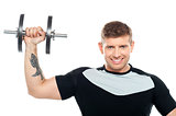 Male instructor posing with raised dumbbell
