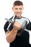 Gym instructor posing with heavy dumbbell