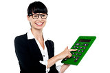 Bespectacled woman using big green calculator