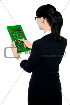 Rear view of corporate woman using green calculator