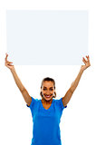 Woman holding up blank white ad board