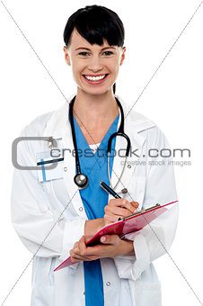 Friendly doctor updating medical record of a patient