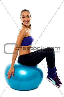 Pretty lady sitting on big blue exercise ball