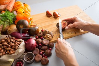 Closeup on young housewife cutting cherokee purple tomato