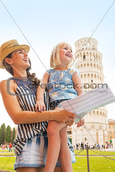 Happy mother and baby girl sightseeing in front of leaning tower