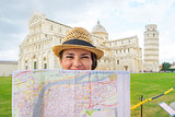 Portrait of happy young woman with map on piazza dei miracoli, p