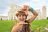 Portrait of happy young woman framing on piazza dei miracoli, pi