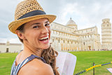 Portrait of smiling young woman with map on piazza dei miracoli,