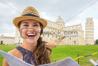 Happy young woman with map pointing on duomo di pisa, pisa, tusc